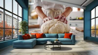 Woman's hands form dough for homemade craft bread.Female baker kneads dough in modern kitchen Wall mural