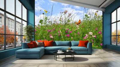 Flowers of clover and wildflowers on meadow in summer. Orange butterfly with black dots scarce copper above summer wildflowers Wall mural