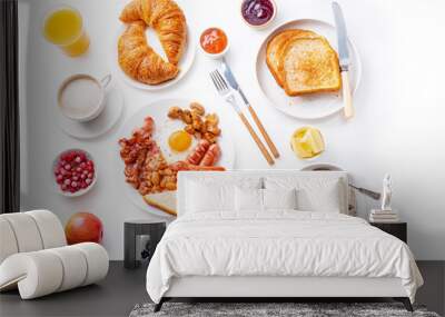 Top view flatlay with varieties of fresh breakfast: fried eggs with bacon and sausages, oatmeal with berries, fried toasts with jam and butter. White background. Wall mural