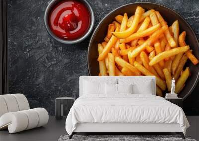 Overhead view of crispy french fries served with rich red ketchup in a dark bowl Wall mural