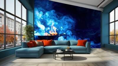 Pot on fire on black background Wall mural