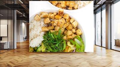 Two vegan asian style bowls with fried tofu, rice, cucumbers, nut sauce seaweed and vegetables. Food sticks. Isolated on white, close up view. Wall mural