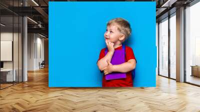 Back to school Portrait of happy surprised kid in glasses isolated on blue background with copy space. new school knowledges Wall mural