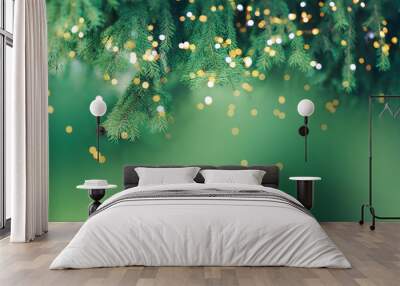 Christmas tree branch with garland in front of green background. Wall mural