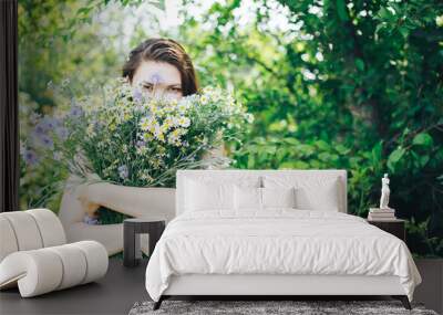 young beautiful woman girl hold big bouquet of wild field flowers Wall mural