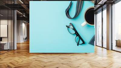 a pair of glasses on a soft blue background Wall mural