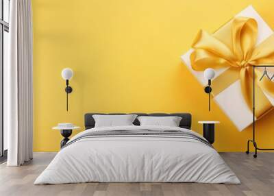 Minimalistic white gift box with luxurious golden ribbon on a bright yellow background. Wall mural