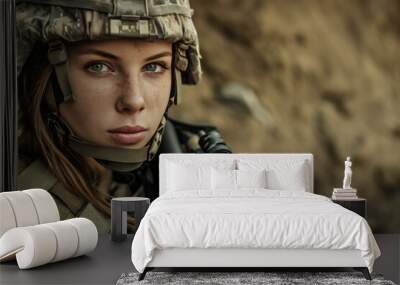 Close-up of a young female soldier with camo helmet and rifle, intense gaze Wall mural