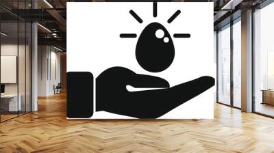 Hand holding a shining light bulb egg, representing a new business idea Wall mural