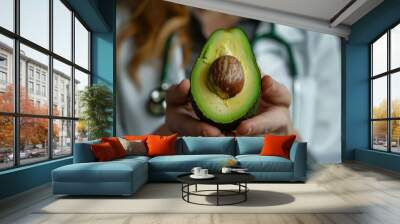 Medical professional holding a ripe avocado, symbolizing healthy eating advice Wall mural