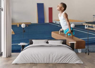 Talented hardworking African boy training indoors at gym, balancing on pommel horse, working on strength, endurance and agility. Fitness, gymnastics, sports, children and motivation concept Wall mural