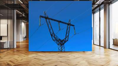 Power line pylon against a bright blue sky. Power transmission tower against the blue sky background. Wall mural