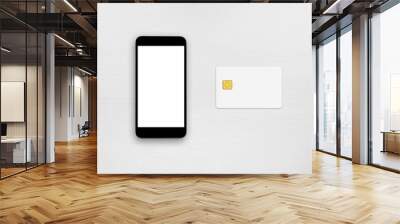 Smartphone and credit card on white table top view Wall mural