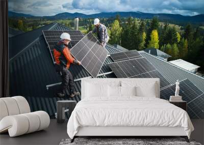 workers building solar panel system on roof of house. men technicians in helmets carrying photovolta Wall mural