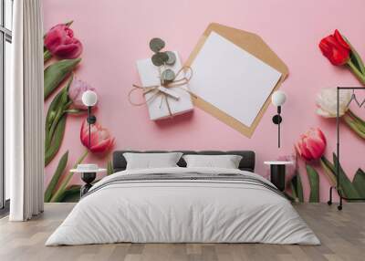 Gift and card on a pink background with tulips. Flat lay and top view. Wall mural