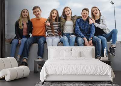 Summer holidays and teenage concept - group of smiling teenagers with skateboard hanging out outside. Wall mural