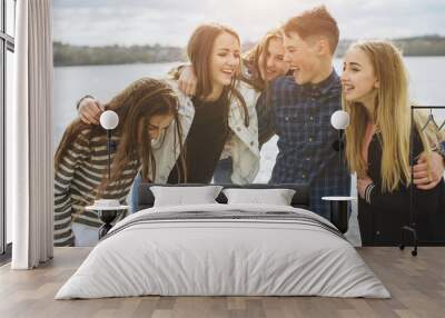 Summer holidays and teenage concept - group of smiling teenagers with skateboard hanging out outside. Wall mural