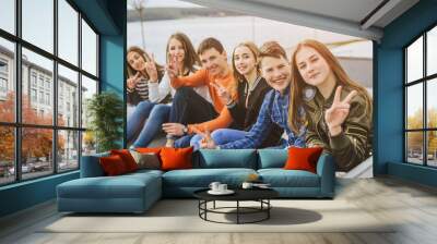 Summer holidays and teenage concept - group of smiling teenagers with skateboard hanging out outside. Wall mural