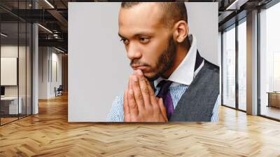 African american man holding hands in prayer hoping for better Wall mural