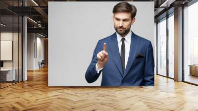 Businessman point finger at invisible screen, hand pushing touch screen, business man pressing digital virtual button isolated over grey background Wall mural