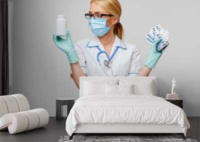 medical doctor nurse woman wearing protective mask and rubber or latex gloves - holding can of medicine and blisters of pills Wall mural