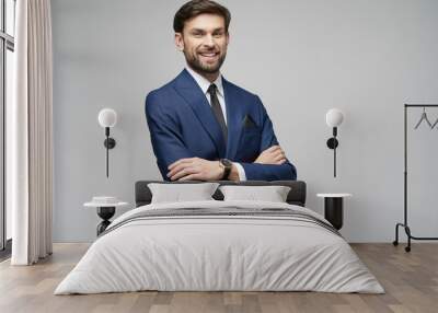 studio photo of young handsome stylish businessman wearing suit Wall mural