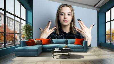 Beautiful teenager girl emotionally gesticulates Wall mural