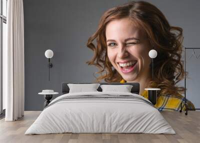 young woman in a yellow shirt expresses emotions on a gray backg Wall mural