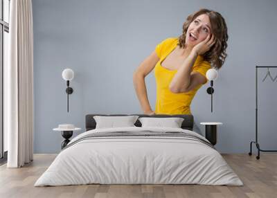 young woman wearing yellow shirt and jeans shorts  over grey bac Wall mural