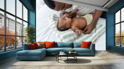 African baby newborn daughter is 3 month old lying on white bed And father are looking into each other's eyes and smiling with happy, to relationship African family and baby newborn concept Wall mural