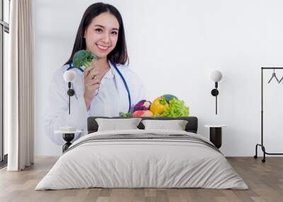 Asian pretty woman doctor, nutritionist holding and showing many fresh vegetables and fruit with high vitamin C, Useful to the body, On white background to haealth care and clean food concept. Wall mural