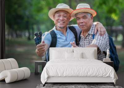 Blurred image of two elderly Asian men hugging their necks and raising their hands to make small hearts. Tourists are impressed with the tour guides. Wall mural