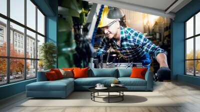 Engineers, experienced technicians Caucasian man are working by controlling steel lathes, in parts production line at workplace in the industrial factory, to worker concept. Wall mural