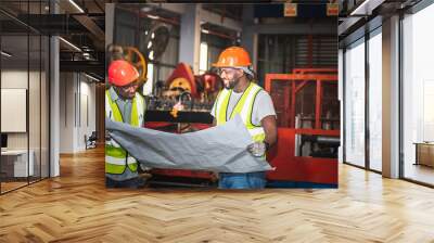 Two male African  are working and looking at blueprint, Consulting and planning collaboration in industrial plant, to workers teamwork industry concept. Wall mural