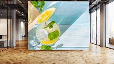 Lemonade and ingredients on blue wood background, copy space Wall mural