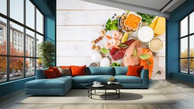 Selection of animal and plant protein sources - fish, meat, beans, cheese, eggs, nuts and seeds, kale, on wood background Wall mural