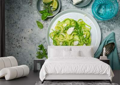 Zucchini noodles with cucumber, feta cheese and arugula, rustic background Wall mural