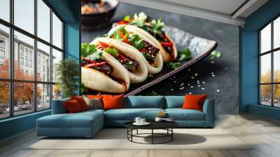 Steamed buns filled with savory pork and fresh herbs on a black plate Wall mural