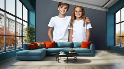 Male and female child, boy and girl, siblings wearing bella canvas white shirt mockup, at dark gray background. Design tshirt template, print presentation mock-up. AI generated. Wall mural