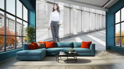 Asian business woman walking beside the outdoor glass curtain wall Wall mural