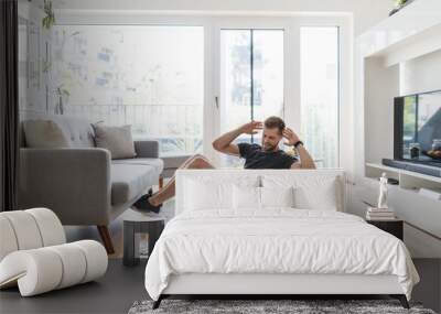 Handsome man working out at home Wall mural