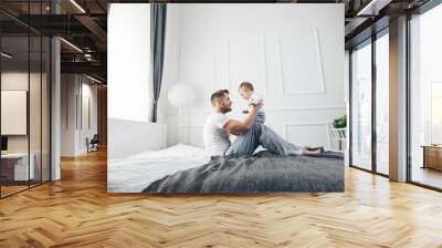 Happy father with his son playing at home on the bed Wall mural