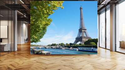 Eiffel tower and Seine river view with green tree branches, sunny Wall mural