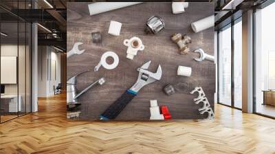 Adjustable wrench, plumbers tools and materials on the wooden background. Wall mural