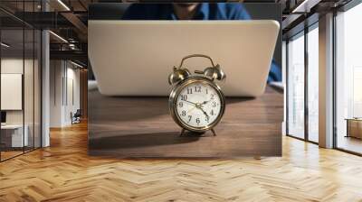 Businessman working at office with a alarm clock on the table. Wall mural