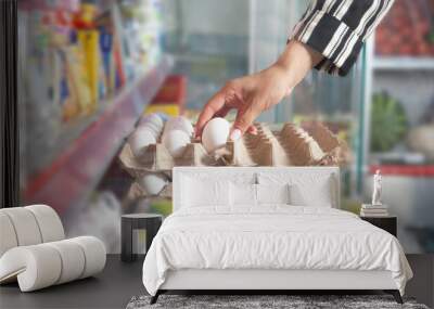 Caucasian woman buying eggs in supermarket. Wall mural