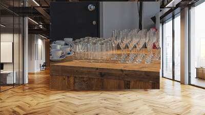 champagne glasses, drinking glasses and cups and saucers stand on a wooden bar Wall mural