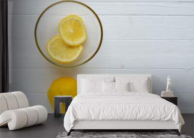 One lemon and two slices of lemon into glass plate. Wall mural