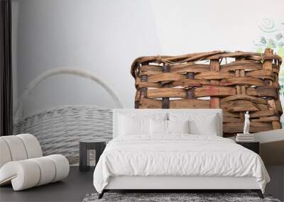 horizontal image of two wicker baskets, one painted white, arranged on a shelf Wall mural