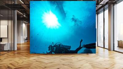 boat ship from underwater blue ocean with sun rays and scuba diver Wall mural